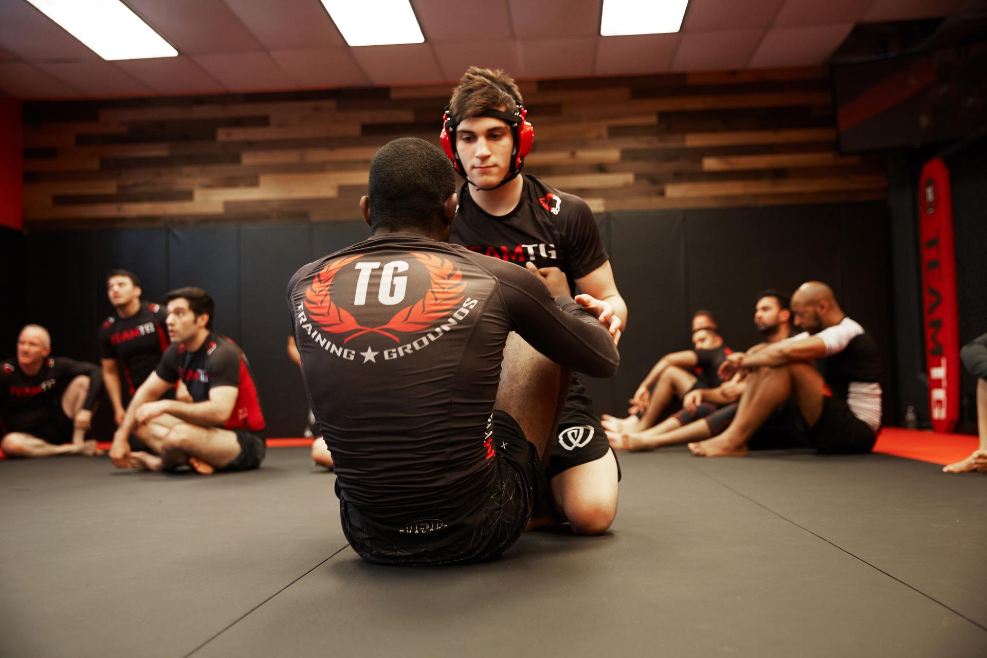 two young men trying to master martial arts by practicing BJJ