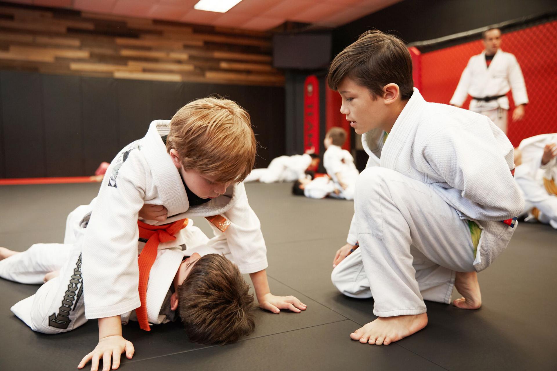 an older child coaching two younger children in a martial arts class in westwood